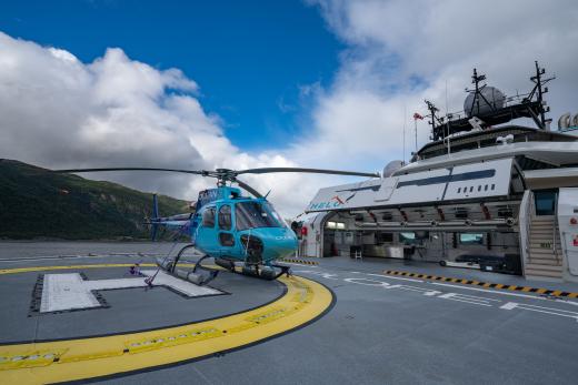 Caption Information: OceanXplorer’s helicopter rests on the vessel’s fully operational landing deck. Credit: Andy Mann